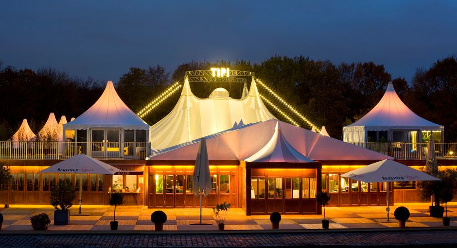 Das Tipi am Kanzleramt mit Terrassen und Lounges bei Nacht.